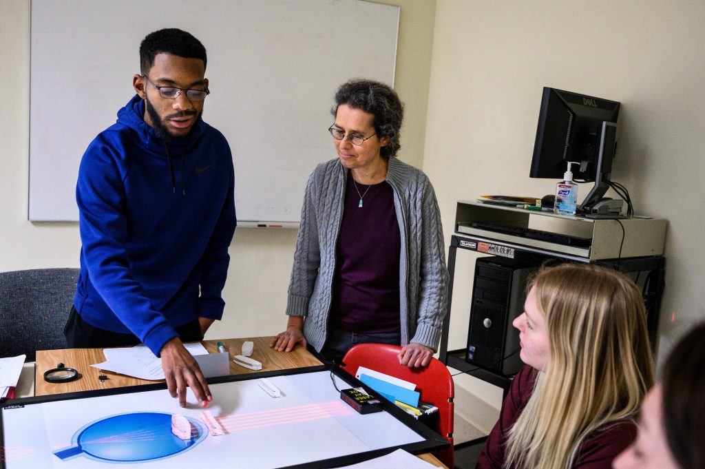 At center, Susan Nossal, director and founder of the Physics Learning Center (PLC), works on optical calculations with undergraduate students Matthew McAllister and Ashley Nelson in a classroom at Chamberlin Hall at the University of Wisconsin-Madison on April 3, 2019. Nossal is one of nine recipients of a 2019 Academic Staff Excellence Award (ASEA). (Photo by Jeff Miller / UW-Madison)